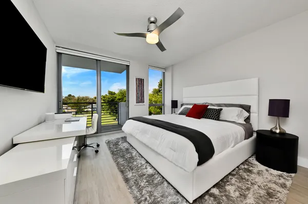 a spacious bedroom with a bed and a large window