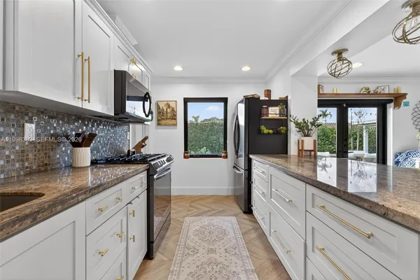 a large kitchen with granite countertop a sink and dishwasher stove top oven