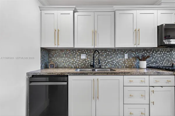a kitchen with granite countertop a sink and a stove
