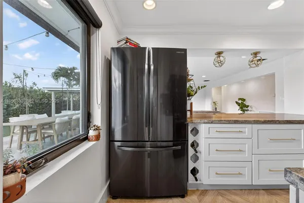 a kitchen with a refrigerator and a wooden floor
