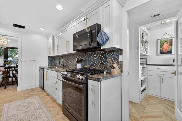 a kitchen with stainless steel appliances granite countertop a stove and a sink