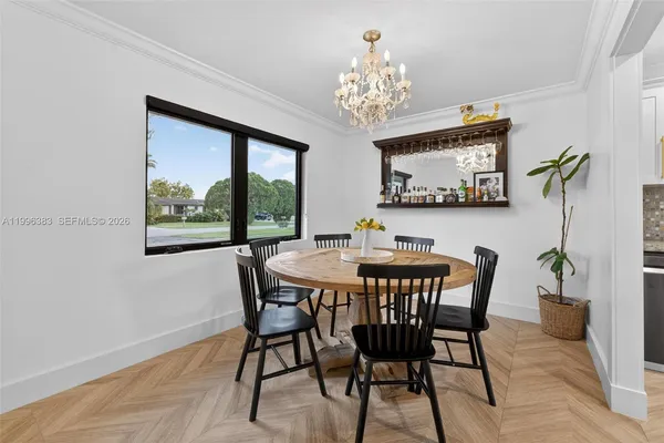a view of a dining room with furniture a chandelier and wooden floor