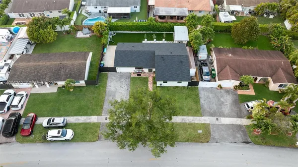 an aerial view of a house with a garden and parking