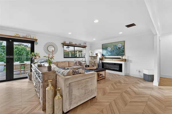 a living room with furniture a fireplace and a floor to ceiling window