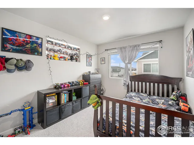 a bedroom with furniture a baby crib and a window