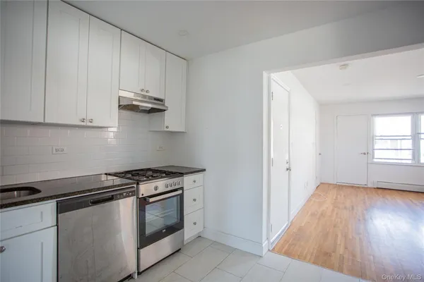 a kitchen with granite countertop white cabinets and white appliances