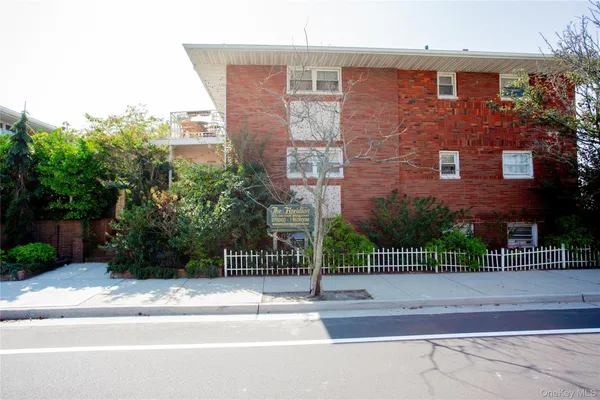 a view of a building with a bench next to a road