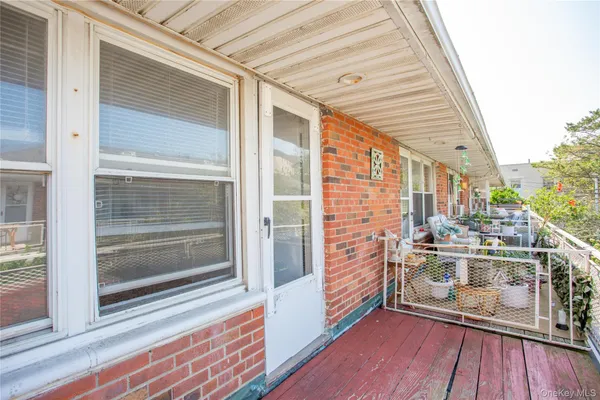 a view of a balcony with floor to ceiling windows with wooden floor