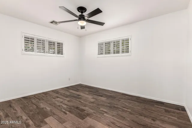 a view of an empty room with a window and a ceiling fan