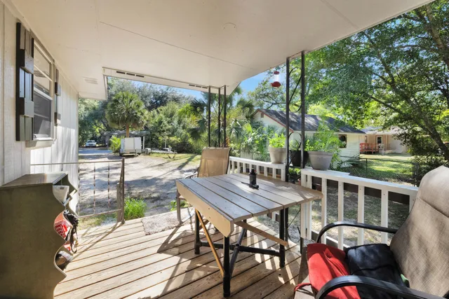 a view of a patio with table and chairs with wooden floor and fence