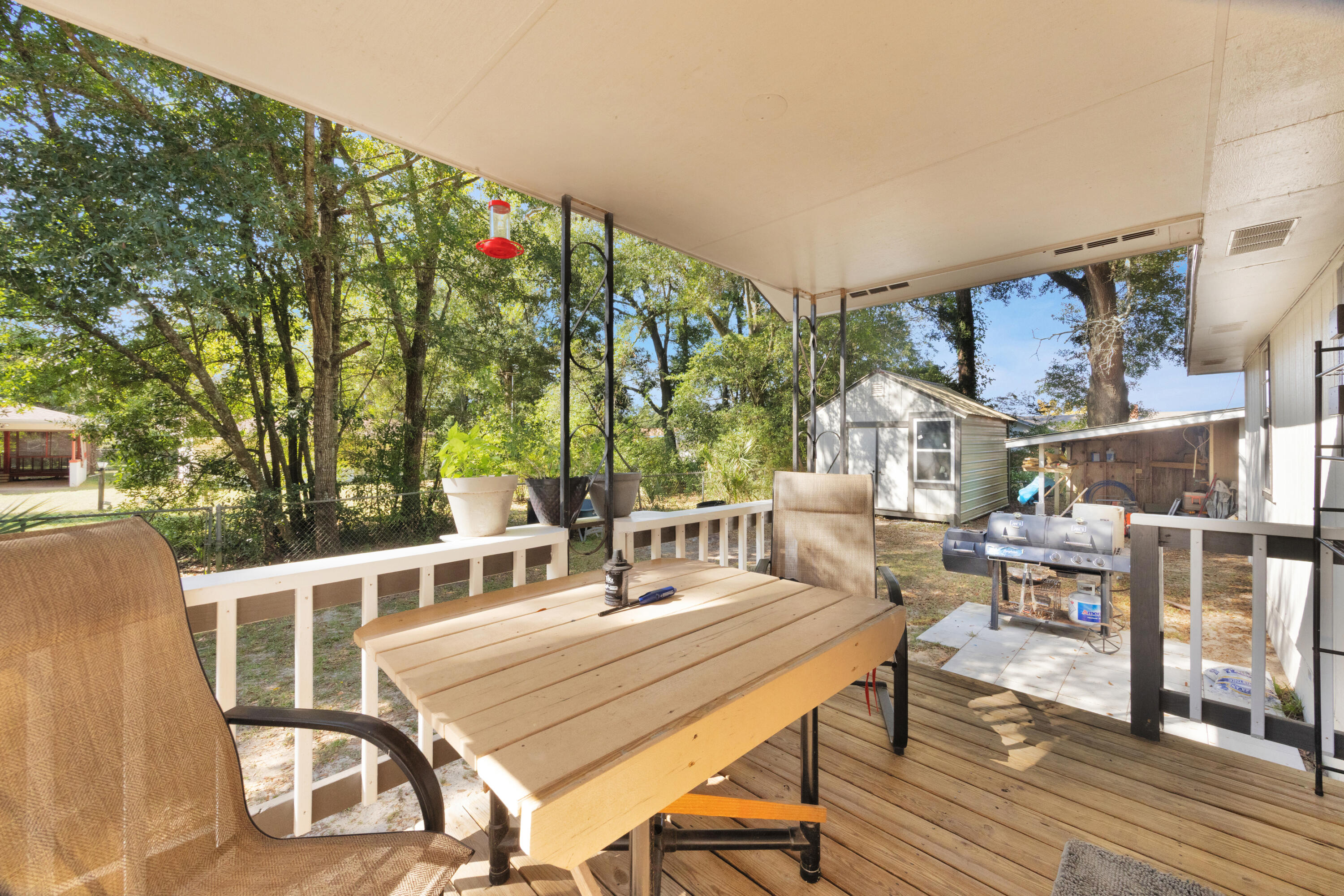 227 East 3rd Avenue Crestview, FL 32536 - Photo 19 of 26 a view of a patio with table and chairs with wooden floor and fence