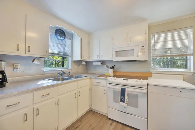 a kitchen with white cabinets and white appliances