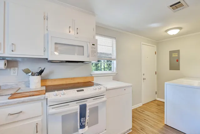a kitchen with stainless steel appliances white cabinets and a stove top oven