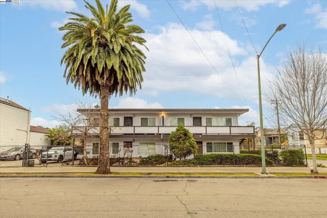 a front view of multiple houses with palm trees