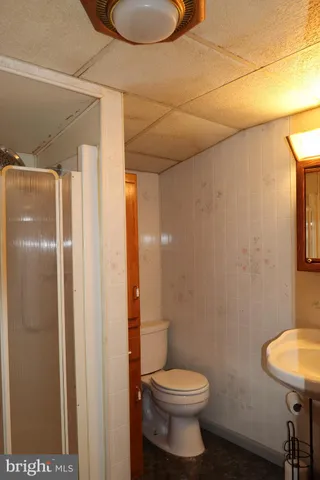 a bathroom with a granite countertop toilet and a sink