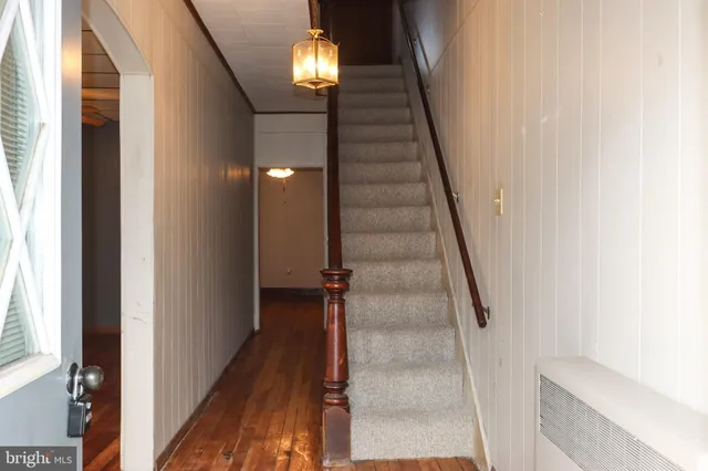 a view of entryway and hall with wooden floor