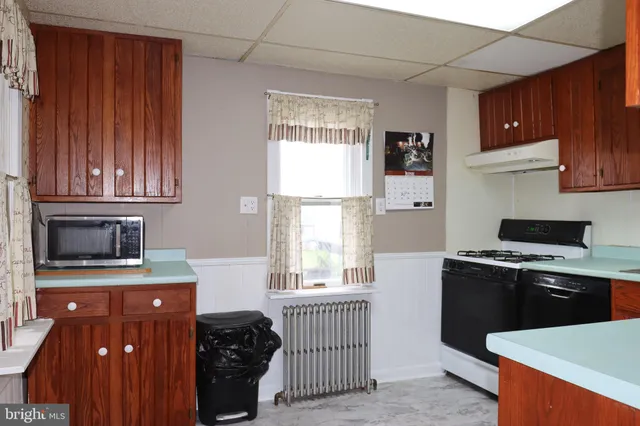 a kitchen with stainless steel appliances granite countertop a stove a sink dishwasher and a microwave oven with cabinets