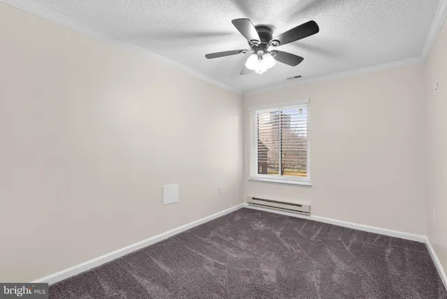 an empty room with a window and a fan