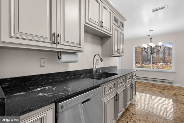 a kitchen with stainless steel appliances granite countertop a sink and cabinets with wooden floor