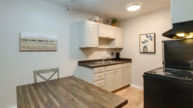 a kitchen with stainless steel appliances a stove refrigerator and sink