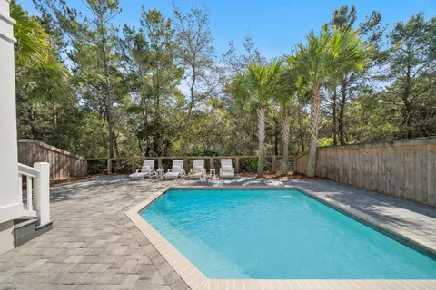 a view of a house with swimming pool and sitting area