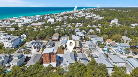 a view of a house with a small yard and a large tree