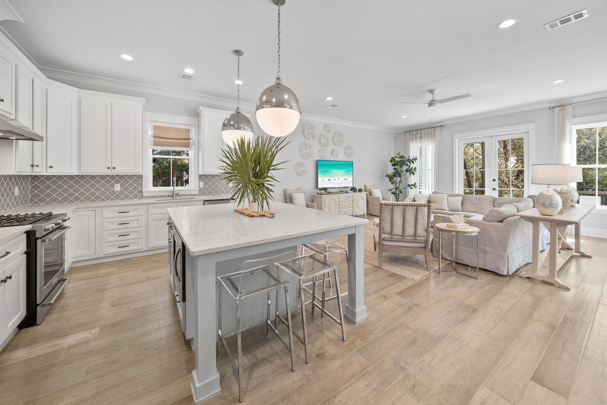 76 Brown Street Santa Rosa Beach, FL 32459 - Photo 7 of 48 a kitchen with stainless steel appliances kitchen island granite countertop a stove a sink a dining table and chairs with wooden floor