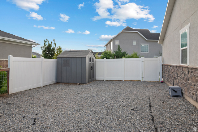 1074 South 750 West Springville, UT 84663 - Photo 27 of 28 Gravel yard with a full perimeter fence and a gray storage shed