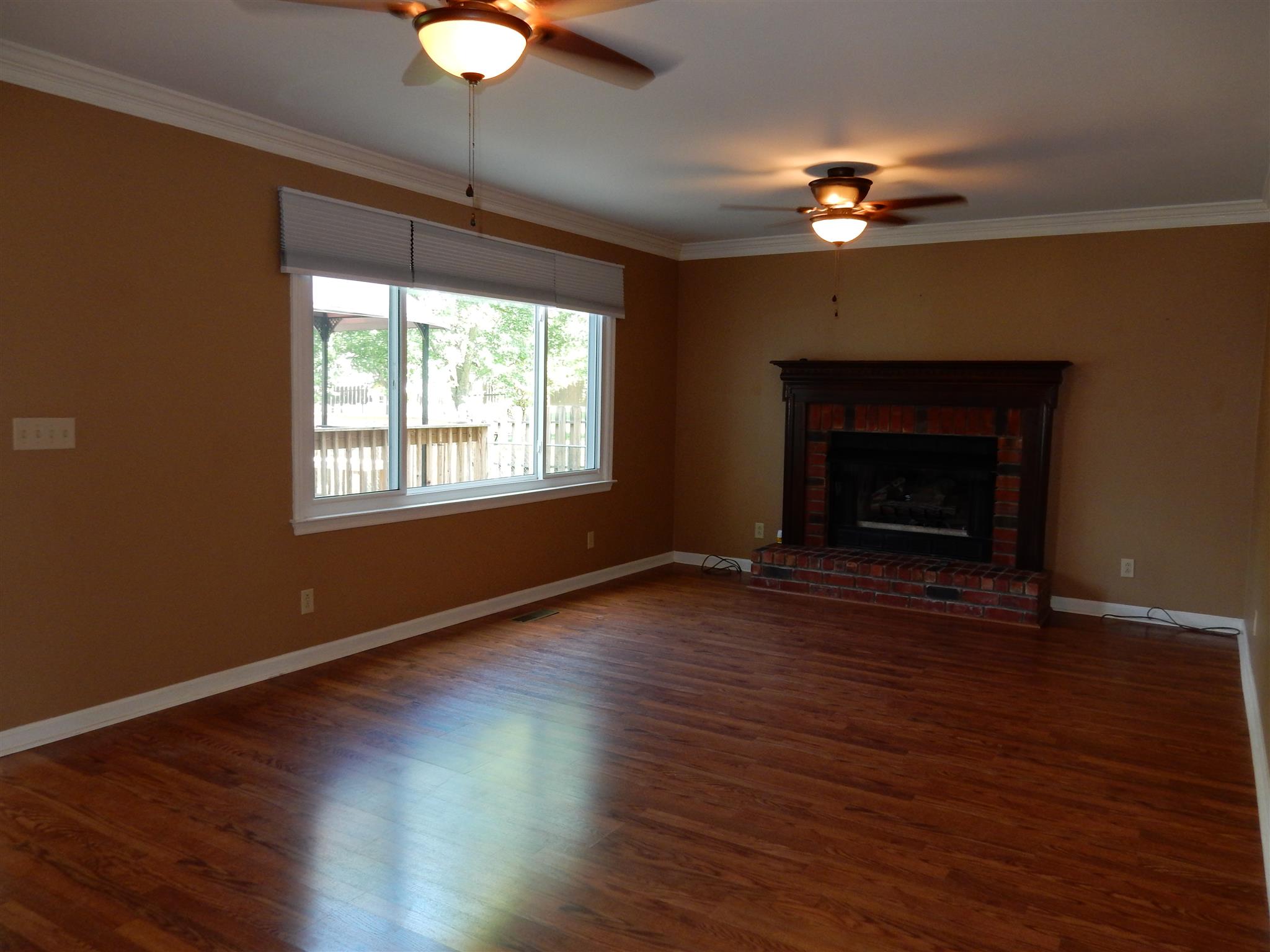 2884 Cages Bend Road Gallatin, TN 37066 - Photo 11 of 26 a view of an empty room with wooden floor fireplace and a window