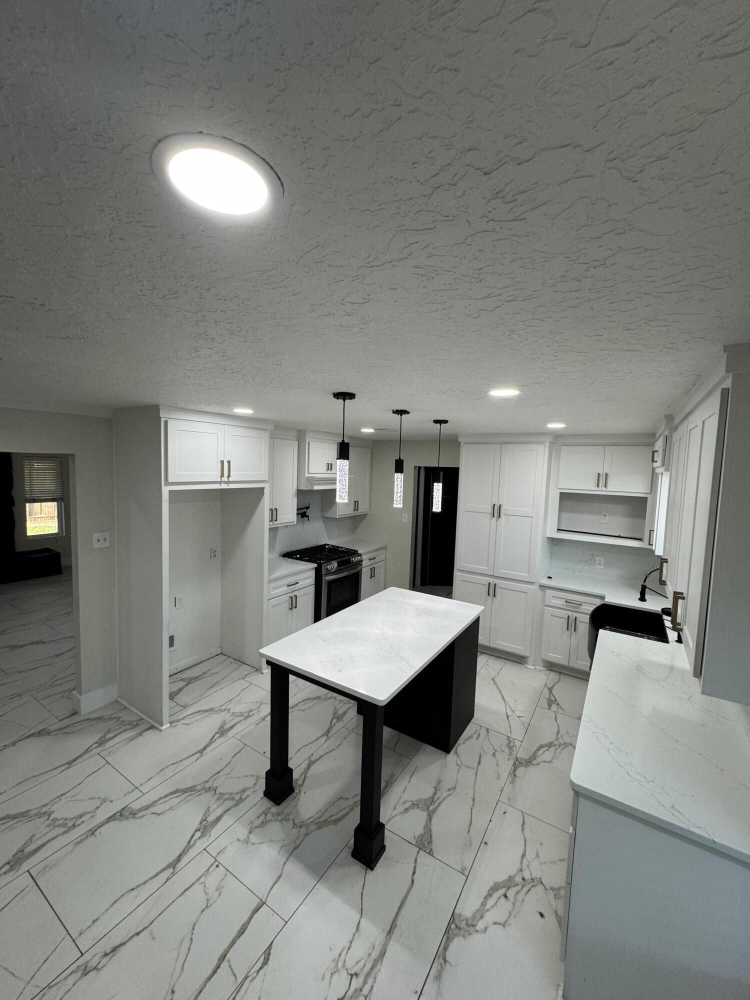 4402 78th Street Lubbock, TX 79424 - Photo 11 of 43 a room with stainless steel appliances kitchen island granite countertop a sink and cabinets