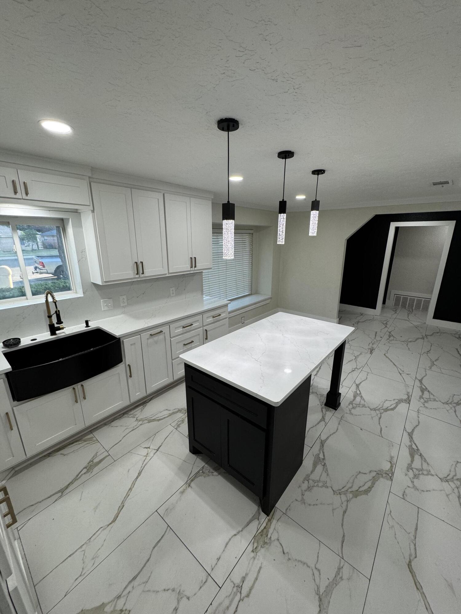 4402 78th Street Lubbock, TX 79424 - Photo 13 of 43 a kitchen with a sink refrigerator and cabinets