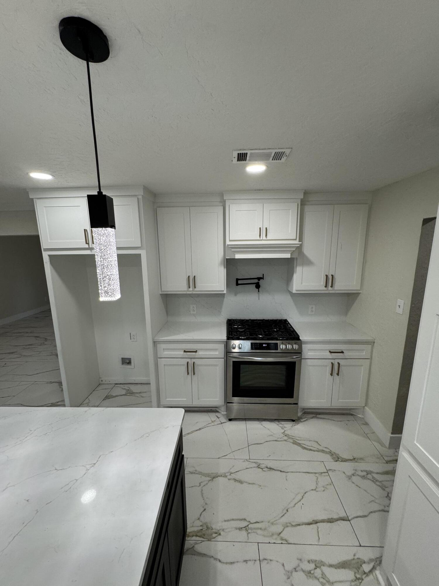4402 78th Street Lubbock, TX 79424 - Photo 14 of 43 a kitchen with a stove a sink and a refrigerator