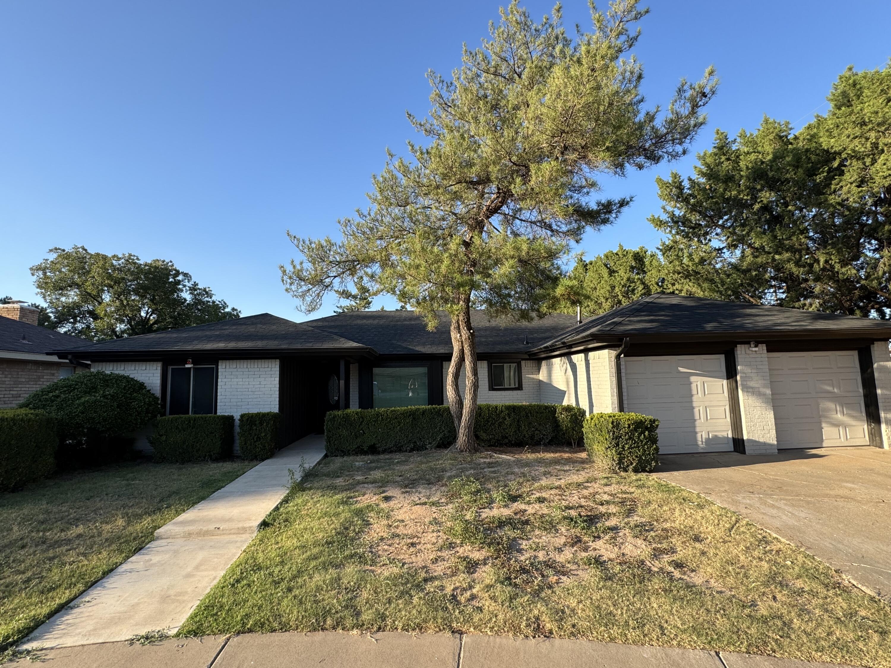 4402 78th Street Lubbock, TX 79424 - Photo 2 of 43 a front view of a house with garden