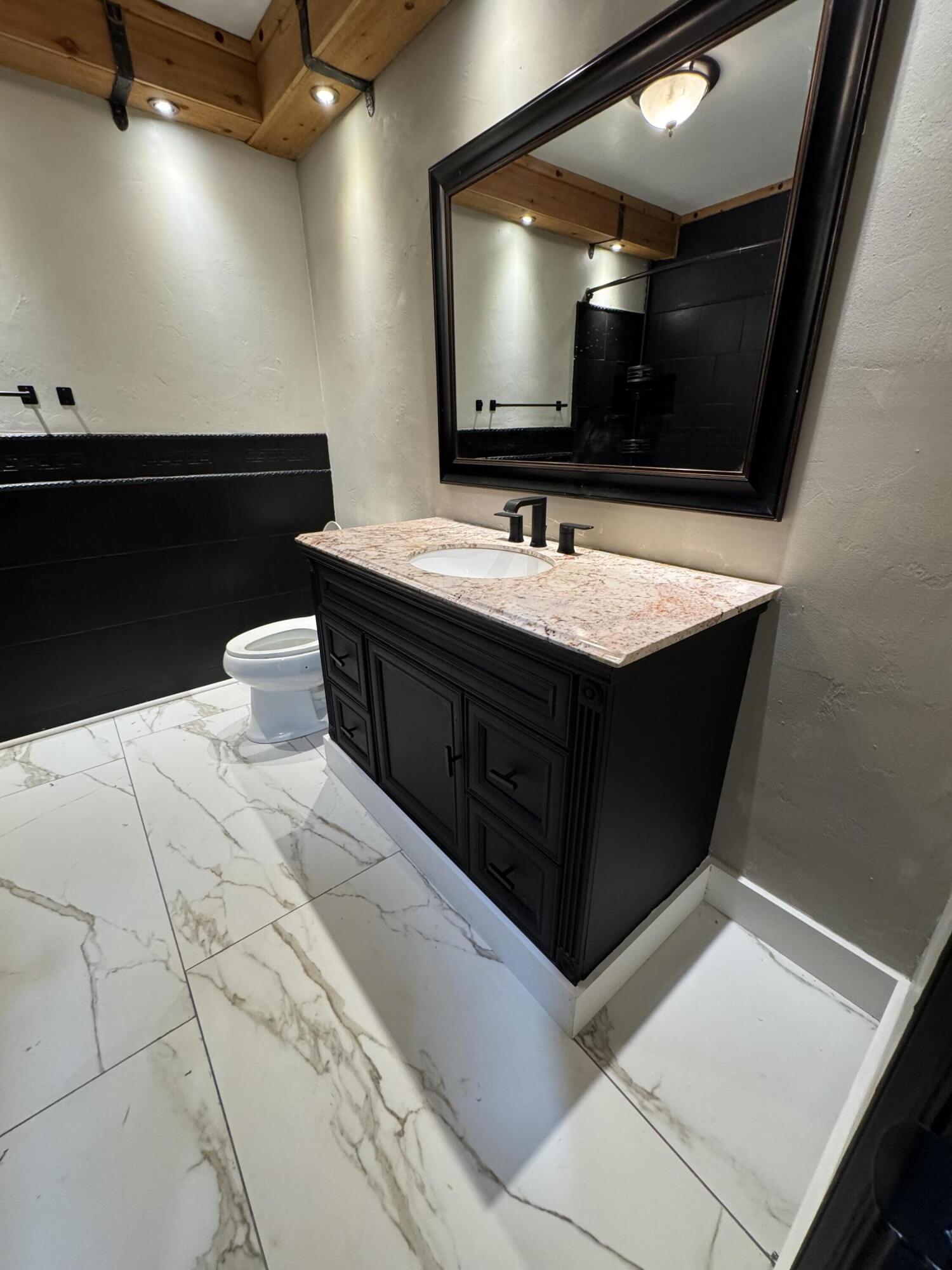 4402 78th Street Lubbock, TX 79424 - Photo 34 of 43 a bathroom with a sink and a mirror