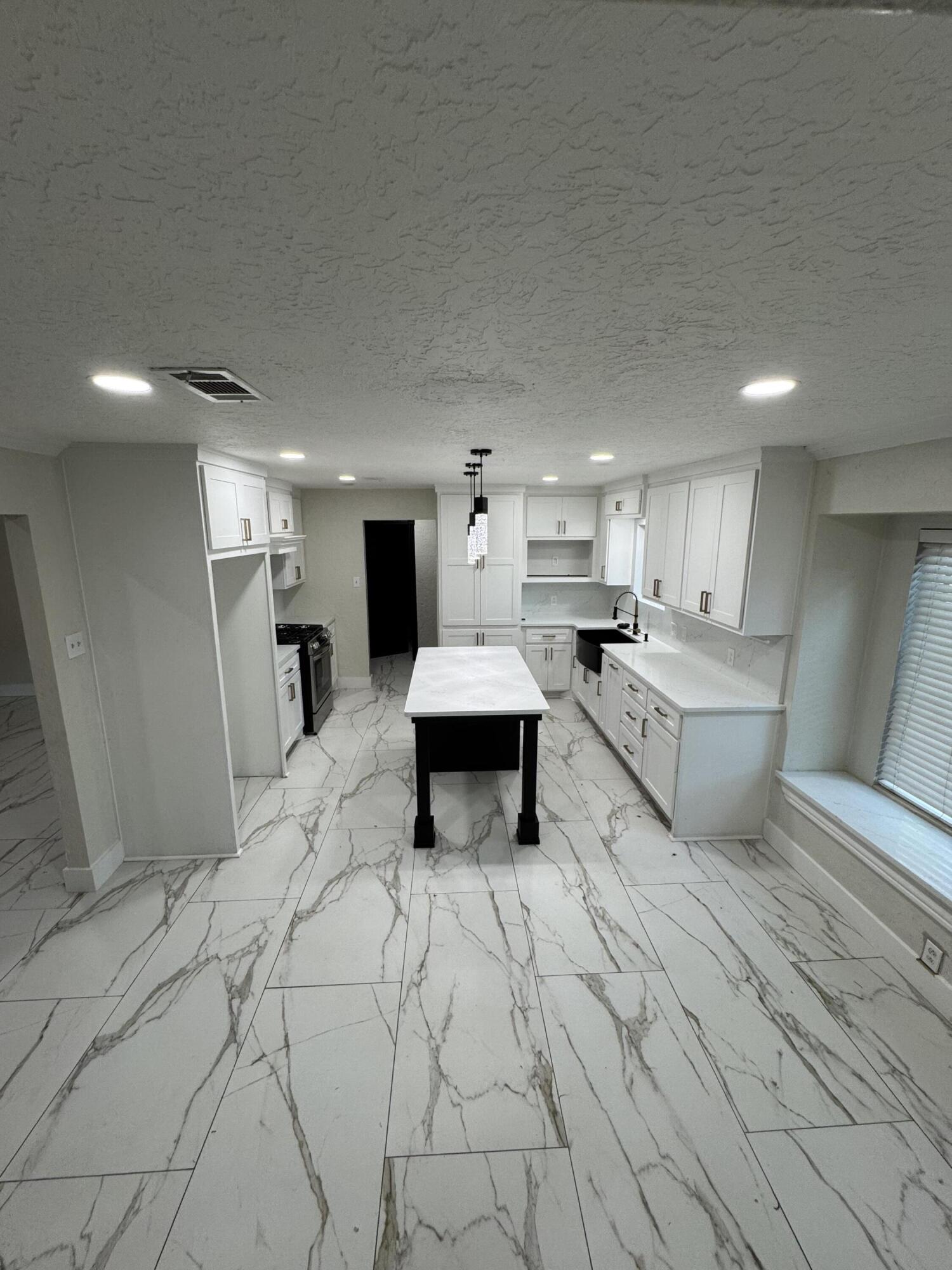 4402 78th Street Lubbock, TX 79424 - Photo 9 of 43 a large white kitchen with a stove and a refrigerator