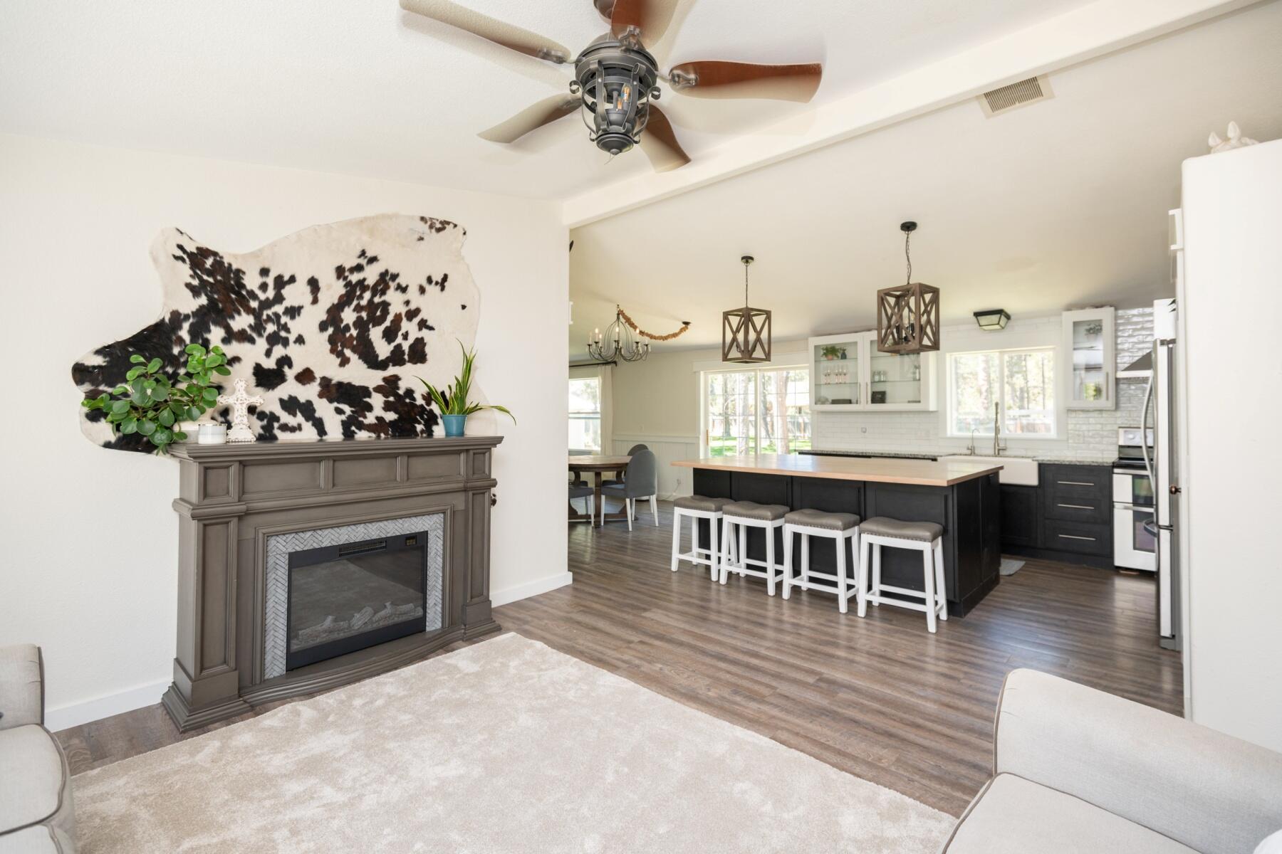 16990 Covina Road Bend, OR 97707 - Photo 24 of 56 a living room with furniture a fireplace and a chandelier