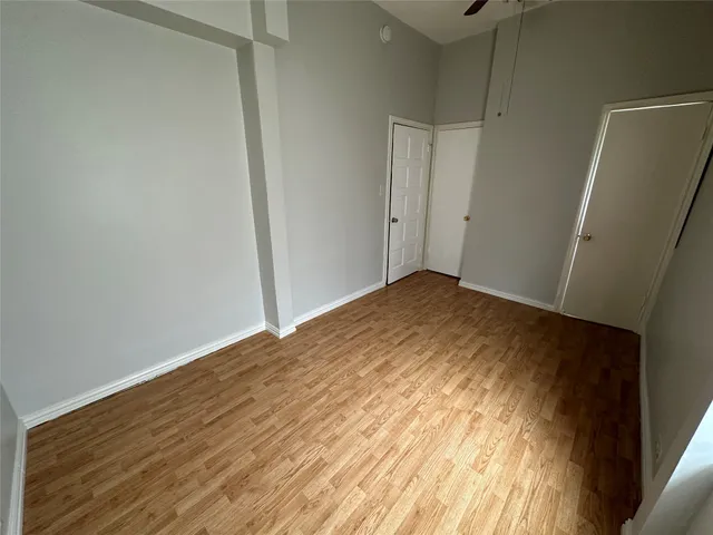 a view of empty room with wooden floor