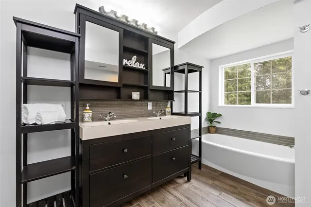 a bathroom with a tub sink and mirror