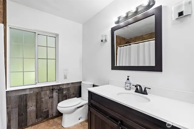 a bathroom with a sink a toilet and mirror