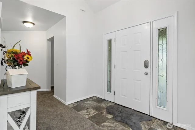 a view of a hallway to room with a fireplace
