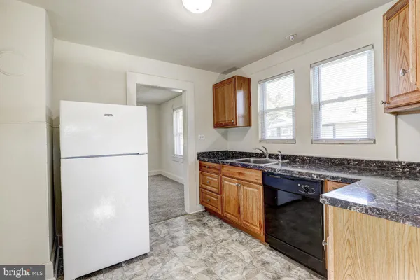 a kitchen with stainless steel appliances granite countertop a refrigerator a sink and a granite counter tops