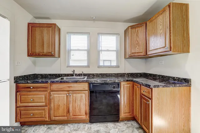 a kitchen with granite countertop a stove and a sink