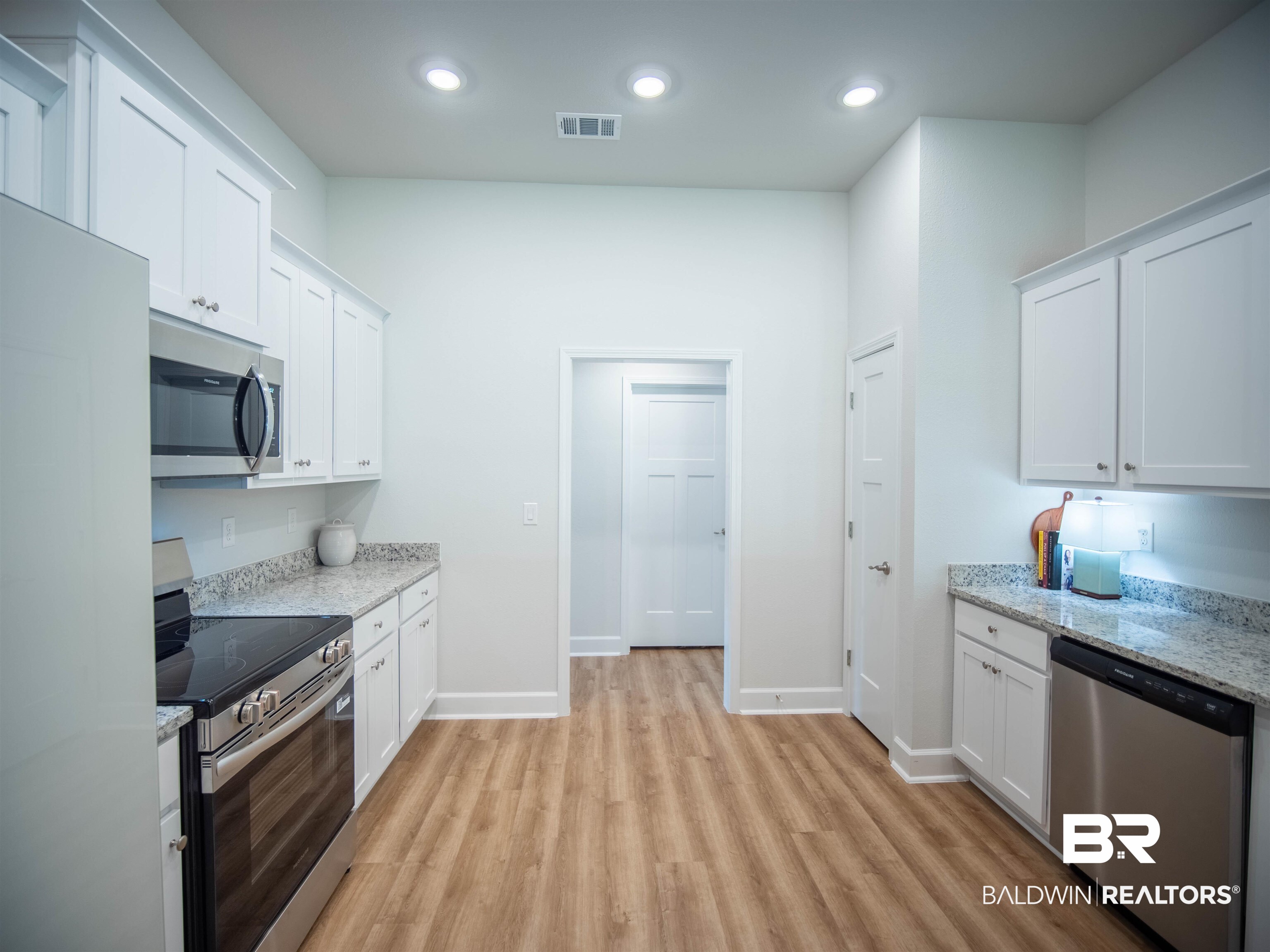 12646 Michigan Avenue Elberta, AL 36530 - Photo 11 of 47 Kitchen featuring stainless steel appliances, light wood-type flooring, white cabinets, light stone countertops, and recessed lighting