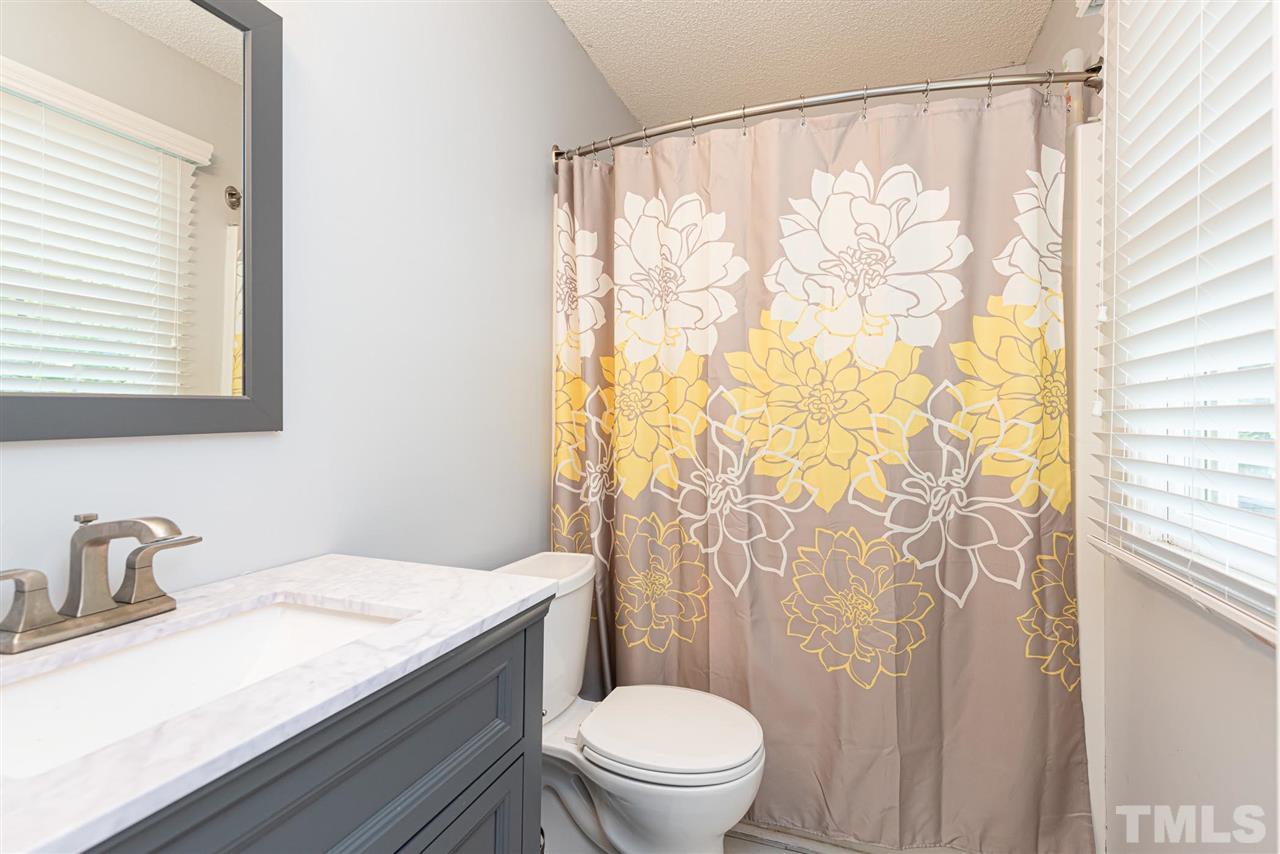 3508 Singleleaf Lane Raleigh, NC 27616 - Photo 16 of 20 a bathroom with a granite countertop sink a toilet and a mirror