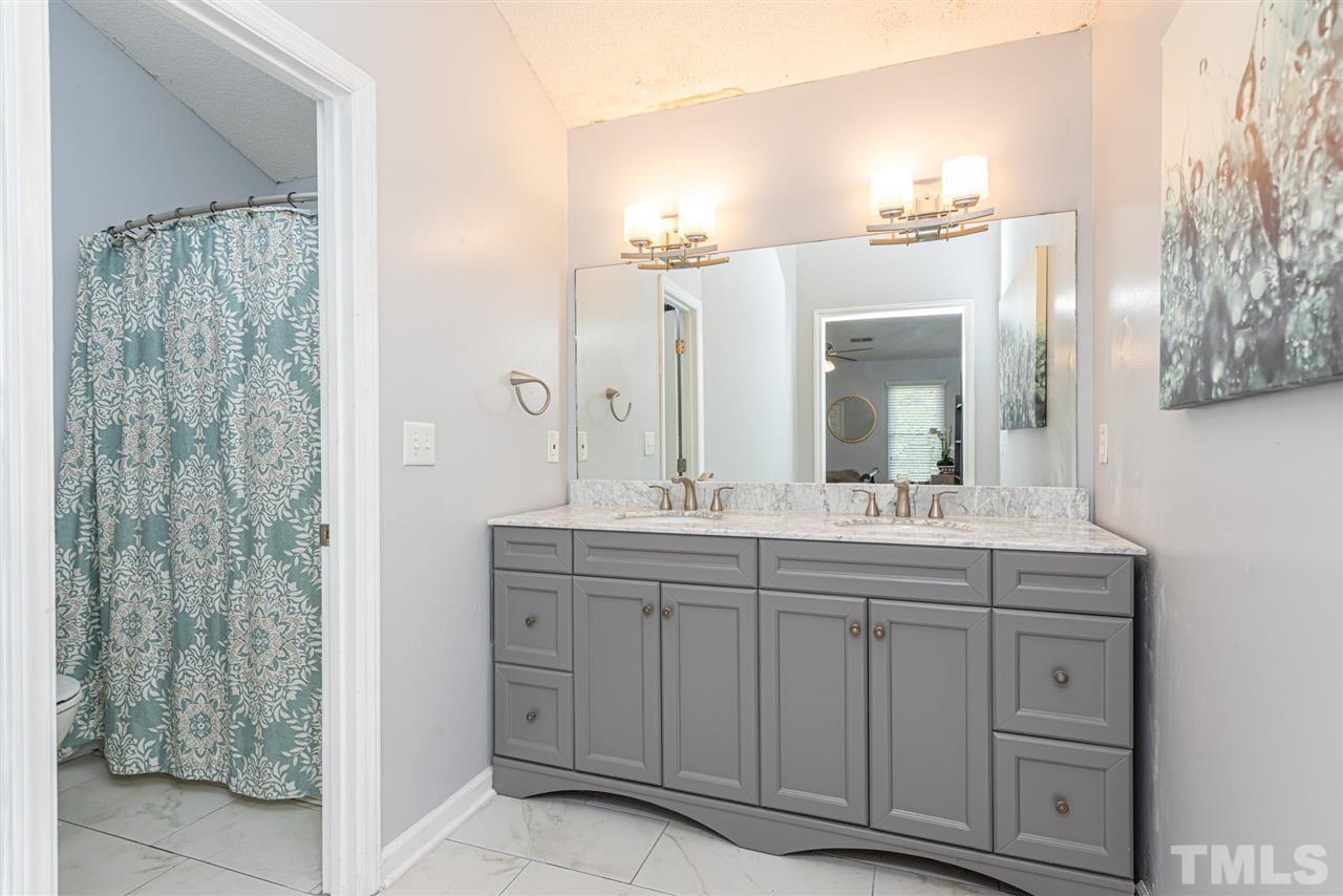 3508 Singleleaf Lane Raleigh, NC 27616 - Photo 9 of 20 a bathroom with a granite countertop sink a mirror and a shower