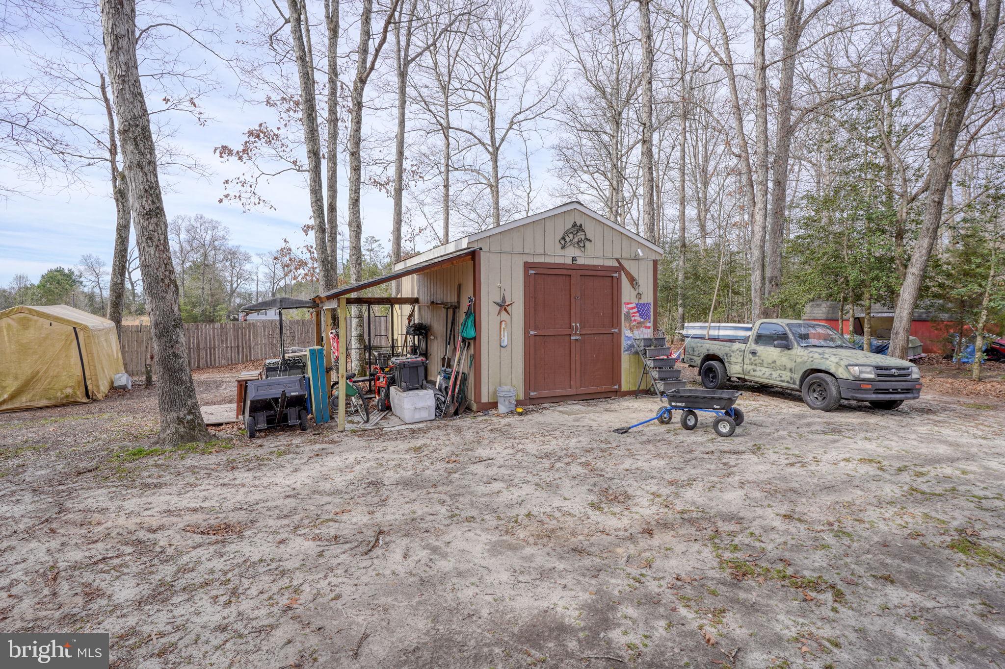 15450 Weigela Drive Georgetown, DE 19947 - Photo 13 of 37 Charming shed nestled among trees.