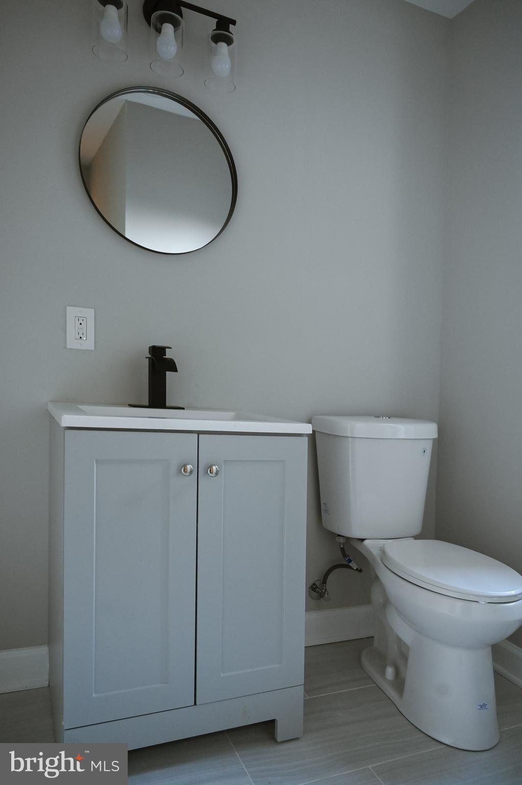 2214 East Fayette Street Baltimore, MD 21231 - Photo 19 of 40 a bathroom with a toilet a sink and mirror