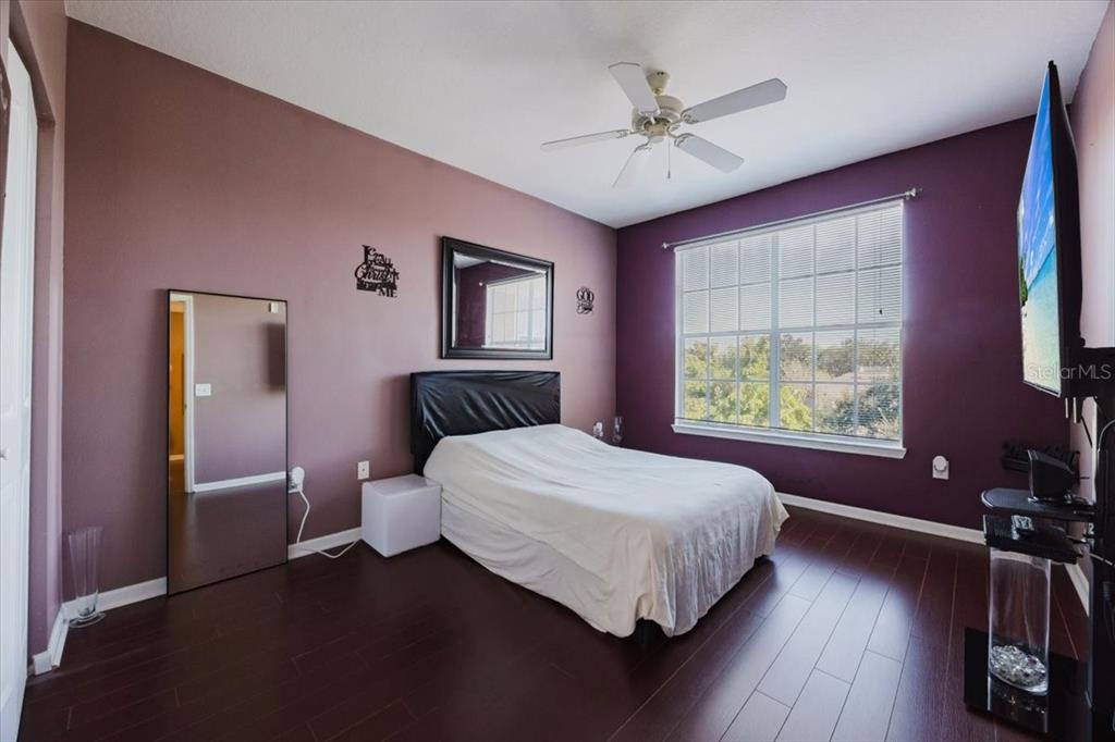 12849 Madison Pointe Circle, Unit 307 Orlando, FL 32821 - Photo 11 of 25 a bedroom with a large bed chandelier and a window