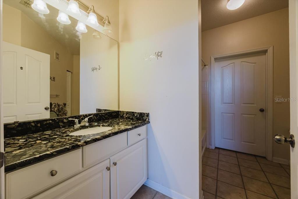 12849 Madison Pointe Circle, Unit 307 Orlando, FL 32821 - Photo 17 of 25 a bathroom with a granite countertop sink and a mirror
