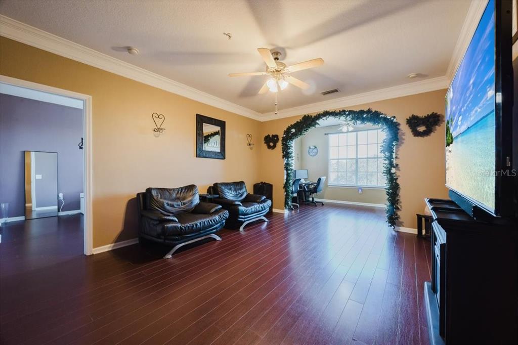 12849 Madison Pointe Circle, Unit 307 Orlando, FL 32821 - Photo 5 of 25 a living room with furniture and a wooden floor
